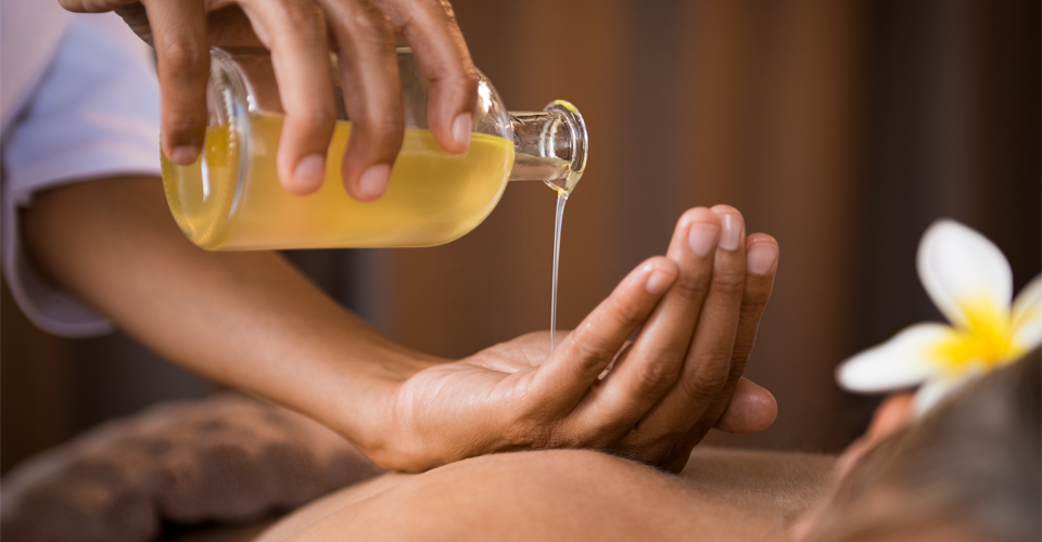 person-massaging-ayurvedic-oil
